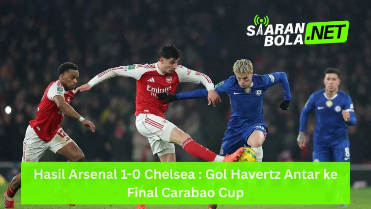 Aksi Kai Havertz dengan jersey merah Arsenal sedang menendang bola dengan kaki kiri di depan pemain Chelsea, Mykhailo Mudryk, dalam laga semifinal Carabao Cup, terdapat logo SIARANBOLA.NET di pojok kanan atas dan teks "Hasil Arsenal 1-0 Chelsea : Gol Havertz Antar ke Final Carabao Cup" pada bilah hijau di bagian bawah.