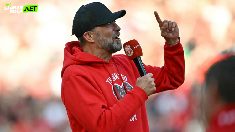 Jurgen Klopp tersenyum di Anfield, memicu spekulasi siaranbola tentang kemungkinan dirinya kembali melatih Liverpool di tengah krisis.