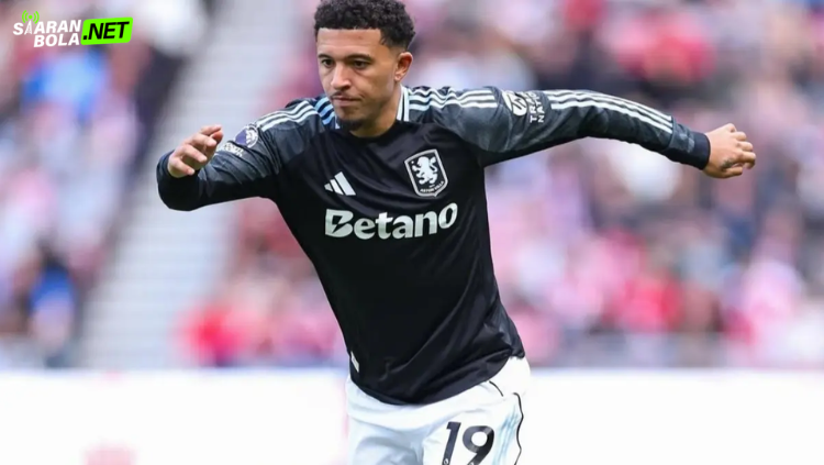 Jadon Sancho sedang memegang bola dengan seragam latihan, ilustrasi masa depannya dibahas di Siaranbola